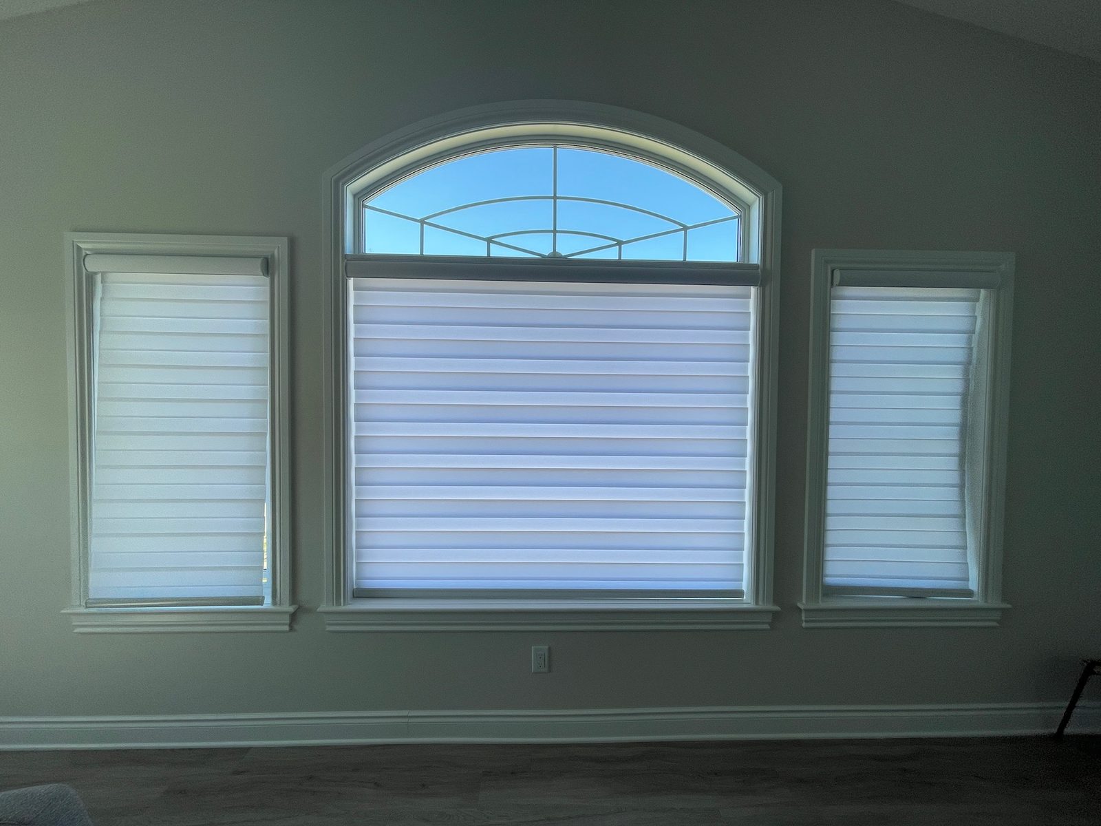 Sheer zebra shades on an arched feature window with two side windows