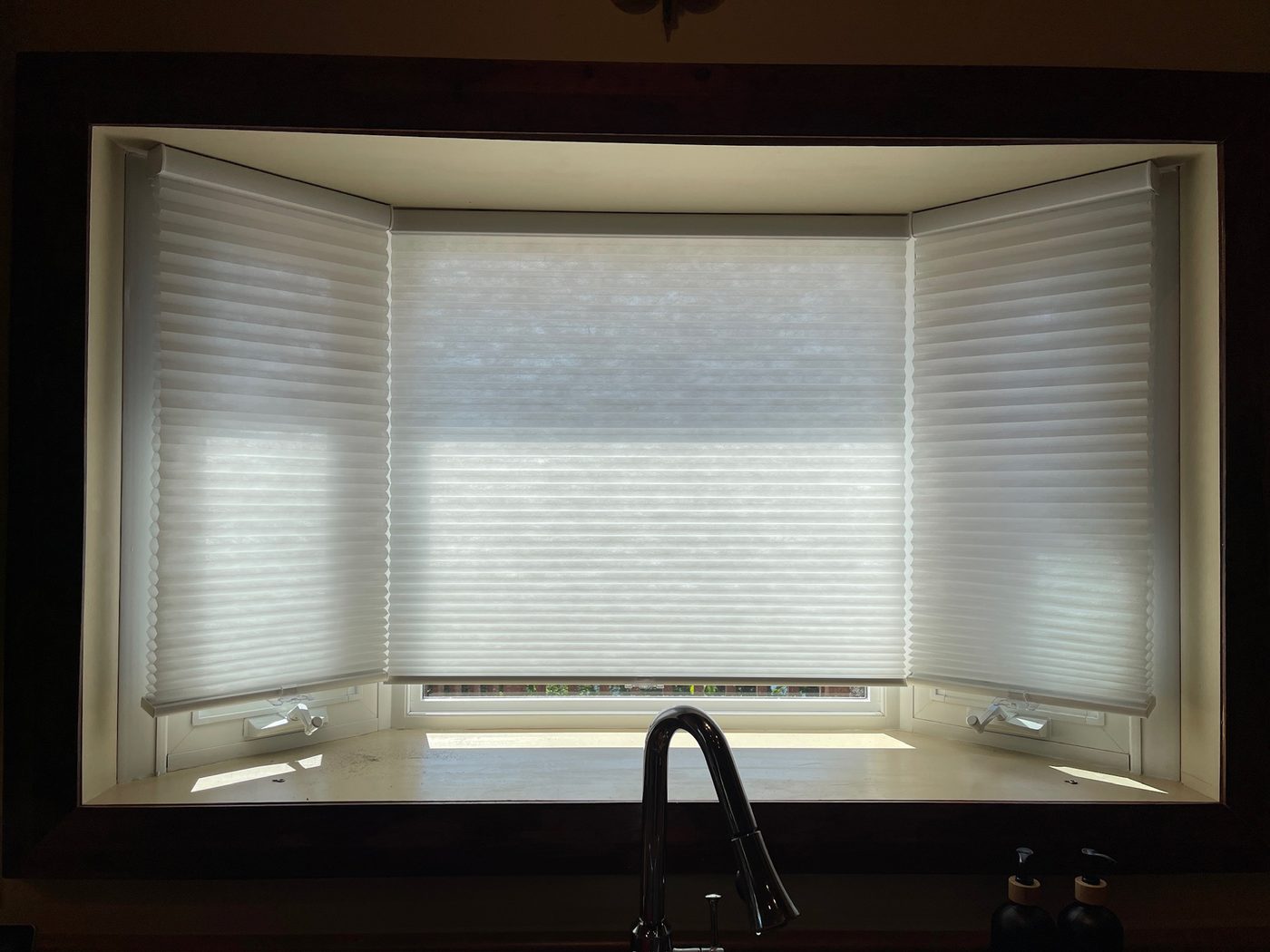 Light-filtering shades fitted to a kitchen bay window